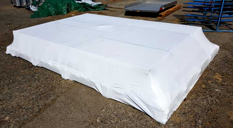 https://shrinkwrapcontainments.com/product_images/uploaded_images/100-shrink-wrap-coverage-of-pallet-for-outdoor-storage-opt.jpg